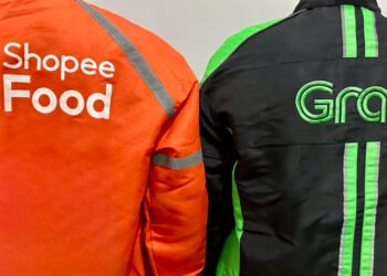 Dua pengemudi ojek online dari ShopeeFood dan Grab saat sedang menunggu pesanan. (Foto Oleh: Michelle Arletta, 21 Mei 2025)