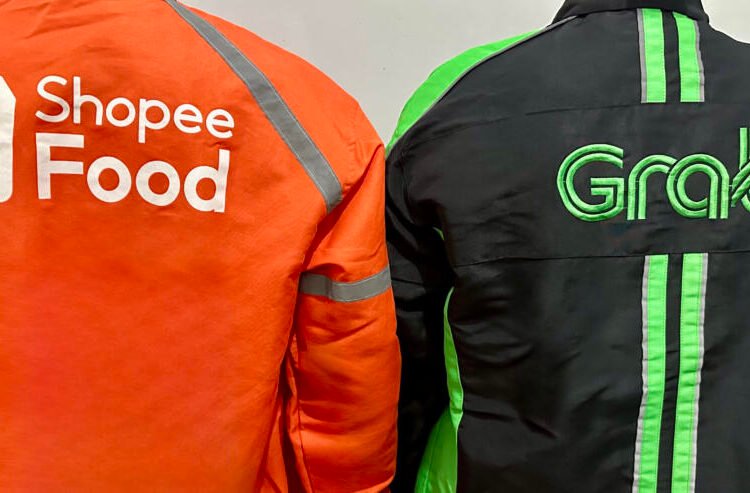 Dua pengemudi ojek online dari ShopeeFood dan Grab saat sedang menunggu pesanan. (Foto Oleh: Michelle Arletta, 21 Mei 2025)