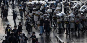 SURABAYA, INDONESIA - MARCH 24: Activists clash with Indonesian Police officers during a protest against the military law revision on March 24, 2025 in Surabaya, Indonesia. On March 20, Indonesia's House of Representatives passed a revision to military law, allowing military officers to serve in more government posts and take up civilian positions without resigning from the Indonesian National Armed Forces. This amendment has drawn criticism from civil society groups, who warn it could signal a return to the repressive New Order era under former President Soeharto, when military officers dominated civilian affairs.Critics argue that this change could lead to abuse of power, human rights violations, and political impunity for army personnel, reminiscent of the era under dictator Suharto, who stepped down in 1998. The timing is particularly significant as Indonesia is now led by President Prabowo Subianto, an ex-special forces general and former son-in-law of Suharto, who was inaugurated in October 2024. (Photo by Robertus Pudyanto/Getty Images)