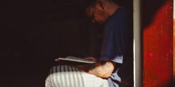 Seorang Warga Binaan sedang menikmati membaca buku di Perpustakaan Pancasila Rutan Kebumen