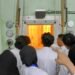 Eksplorasi Laboratorium Reaktor Nuklir: Dari Perangkat hingga Proses Reaksi 15 Ruang dengan kaca tebal dan lampu oranye kemungkinan adalah ruang hot cell atau reaktor mini, tempat reaksi nuklir atau penanganan material radioaktif berlangsung secara aman. Dinding dan panel besi tebal merupakan pelindung radiasi.
