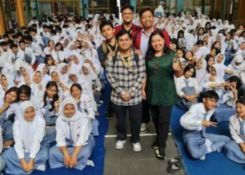Mahasiswa Fakultas Hukum Universitas Muhammadiyah Malang (UMM) yang terdiri dari Faza Asriel Athallah, Permana Brahmana Putra, Muhammad Afif Wibowo, Nandito Dimetry Irzaki, dan Achmad Yusril Abdillah, di bawah bimbingan Dosen Pembimbing Lapangan (DPL) Daisy Pangalila, S.Th., melaksanakan kegiatan sosialisasi dan pendidikan hukum di SMK Negeri 1 Kota Batu. Kegiatan ini bekerja sama dengan LBH APIK dan mengangkat isu krusial: pencegahan seks bebas dan bullying di kalangan remaja. Sosialisasi dan pendidikan merupakan dua pendekatan penting dalam membentuk kesadaran hukum serta karakter siswa. Kegiatan ini bertujuan menanamkan nilai moral, empati, dan tanggung jawab sosial, serta memberikan pemahaman terkait risiko dari perilaku menyimpang. Hal ini sejalan dengan amanat Undang-Undang Nomor 23 Tahun 2002 jo. UU Nomor 35 Tahun 2014 tentang Perlindungan Anak, serta Undang-Undang Nomor 12 Tahun 2022 tentang Tindak Pidana Kekerasan Seksual (UU TPKS), yang mendorong pencegahan melalui pendidikan dan partisipasi masyarakat. Sosialisasi berfungsi sebagai proses pencegahan dini melalui internalisasi nilai dan norma sosial. Melalui diskusi interaktif dan simulasi kasus, siswa dibimbing untuk memahami pentingnya menghargai batasan pribadi dan menghindari kekerasan. Sekolah menjadi tempat strategis dalam mengimplementasikan nilai ini, terutama melalui pelajaran seperti Pendidikan Pancasila, Pendidikan Agama, dan Bimbingan Konseling. Di sisi lain, pendidikan formal di sekolah juga memegang peran penting dalam membekali remaja dengan pemahaman tentang tubuh, relasi sehat, dan risiko seks bebas. Kurikulum yang sensitif usia dan budaya, serta integrasi pendidikan karakter, membantu siswa mengembangkan empati, kemampuan mengambil keputusan, dan ketahanan moral. Peran guru sangat vital dalam pencegahan. Selain menyampaikan materi ajar, guru juga menjadi teladan dalam bersikap dan berinteraksi. Keteladanan guru menciptakan lingkungan yang aman, memungkinkan siswa terbuka dalam menyampaikan permasalahan, termasuk yang berkaitan dengan seksualitas atau perundungan. Sementara itu, orang tua memiliki peran sebagai pendidik pertama dalam keluarga. Pendidikan seksual sejak dini yang dilakukan secara jujur dan terbuka akan membantu anak mengenal tubuhnya, memahami risiko, dan menjaga harga diri. Lingkungan keluarga yang empatik dan komunikatif mencegah anak menjadi pelaku atau korban bullying. Di era digital, pengawasan orang tua terhadap aktivitas daring anak menjadi penting untuk mencegah paparan konten negatif dan relasi tidak sehat. Kolaborasi antara guru dan orang tua menjadi kunci dalam membentuk ekosistem yang mendukung tumbuh kembang anak secara utuh. Komunikasi aktif melalui forum wali murid dan pelatihan parenting menciptakan keselarasan nilai dan pendekatan antara rumah dan sekolah. Dengan kegiatan ini, mahasiswa FH UMM dan LBH APIK berharap dapat membangun kesadaran hukum sejak dini pada siswa, serta mendorong terciptanya lingkungan pendidikan yang aman, berdaya, dan bebas dari kekerasan serta perilaku menyimpang.