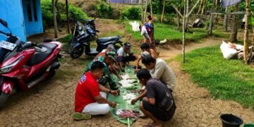 Anggota Satgas TMMD Ke-129 Kodim 0601/Pandeglang makan bersama warga di lokasi kegiatan TMMD di Kecamatan Patia.