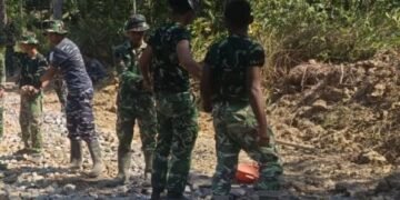 Personel Satgas TMMD Ke-129 Kodim 0601/Pandeglang bersama warga melaksanakan pengerasan badan jalan menggunakan batu di Desa Pasirgadung, Kecamatan Patia, Kabupaten Pandeglang.