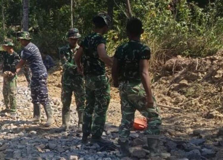 Personel Satgas TMMD Ke-129 Kodim 0601/Pandeglang bersama warga melaksanakan pengerasan badan jalan menggunakan batu di Desa Pasirgadung, Kecamatan Patia, Kabupaten Pandeglang.