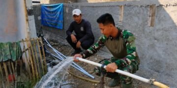 Personel Satgas TMMD Ke-129 Kodim 0601/Pandeglang bersama warga menunjukkan sumur bor yang berhasil mengalirkan air bersih di Masjid Kampung Pangburangan, Desa Pasirgadung, Kecamatan Patia, sebagai solusi kebutuhan air bersih masyarakat saat musim kemarau.