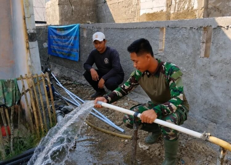 Personel Satgas TMMD Ke-129 Kodim 0601/Pandeglang bersama warga menunjukkan sumur bor yang berhasil mengalirkan air bersih di Masjid Kampung Pangburangan, Desa Pasirgadung, Kecamatan Patia, sebagai solusi kebutuhan air bersih masyarakat saat musim kemarau.
