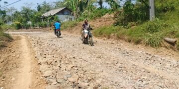 Warga Desa Pasirgadung melintasi jalan hasil pengerasan Program TMMD Ke-129 Kodim 0601/Pandeglang di Kecamatan Patia, Kabupaten Pandeglang, yang kini mulai dimanfaatkan untuk memperlancar aktivitas sehari-hari.