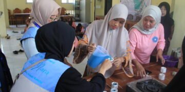 Perwakilan PKK Desa Sedayu didampingi mahasiswa KKN UIN Walisongo Posko 173 saat menuangkan lilin cair ke dalam cetakan.(Foto: Dok. KKN)