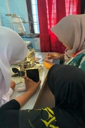 Menjahit Kompetensi, Merajut Masa Depan: Penguatan Keterampilan Murid SMKN 1 Depok untuk Mendukung SDGs 8 7 Gambar 2. Kegiatan praktik pengoperasian mesin jahit oleh murid kelas X dengan didampingi mahasiswa praktikan.