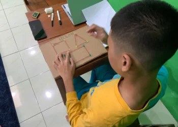 Mahasiswa UNY Kembangkan Media Konkret Sederhana Berbasis SDGs untuk Pembelajaran Matematika Murid Autisme Fase D 1 Murid menggunakan media bangun datar berbahan kardus untuk memahami konsep keliling sebagai jumlah seluruh sisi.