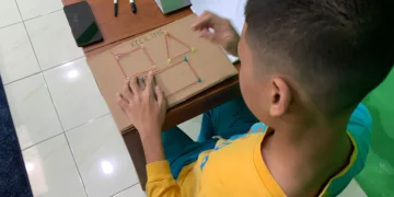Murid menggunakan media bangun datar berbahan kardus untuk memahami konsep keliling sebagai jumlah seluruh sisi.