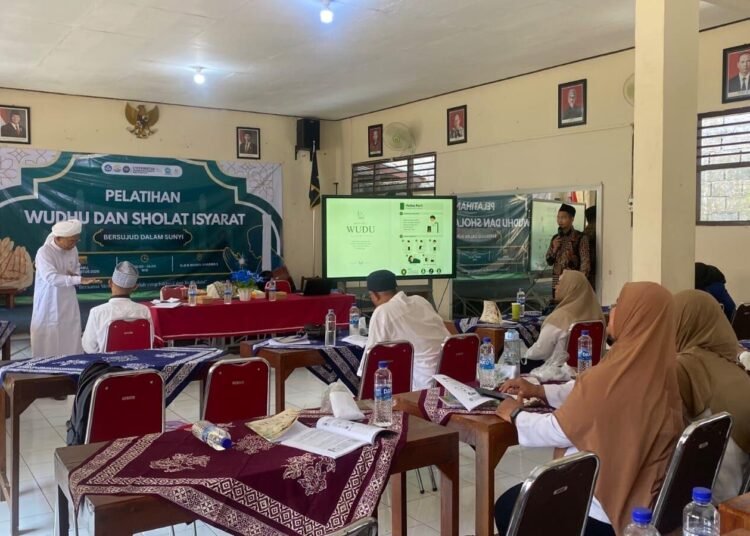 Merangkul keheningan dalam ibadah: Pelatihan Sholat dan Wudhu isyarat di SLB-B Sleman, 19 Agustus 2026- Dalam rangka memperluas akses Pendidikan yang inklusif bagi murid berkebutuhan khusus, SLB-B Wiyata Dharma 1 Sleman Bersama Universitas Negeri Yogyakarta dan Pondok Pesantren Darul Ashom mengadakan pelatihan Sholat dan Wudhu dengan Bahasa isyarat. Acara ini diikuti oleh para guru SLB-B Wiyata Dharma 1 Sleman dan sejumlah Mahasiswa Praktik Kependidikan (PK) dari Program Pendidikan Luar Biasa UNY. Pelatihan di laksanakan SLB-B Wiyata Dharma 1 Sleman pada tanggal 19 Agustus 2026 hari Rabu, guna untuk membekali para pendidik dengan kemampuan mendampingi murid yang memiliki hambatan pendengaran. Kegiatan ini berkontribusi nyata terhadap SDG 4 (Pendidikan Berkualitas), khususnya target 4,4 yang menekankan penghapusan kesenjangan dan jaminan akses Pendidikan yang setara bagi kelompok disabilitas, dalam hal ini melalui peningkatan kapasitas guru sebagai ujung tombak Pendidikan inklusif. Selain itu, kegiatan ini juga sejalan dengan SDG 10 (Berkurangnya kesenjangan), sebab memastikan bahwa hak menjalankan ibadah dapat difasilitasi secara setara oleh tenaga pendidik yang kompeten dan memahami kebutuhan komunikasi murid hambatan pendengaran. Rangkaian acara diawali dengan penyampaian materi seputar huruf hijaiyah dan bacaan Al-quran menggunakan Bahasa isyarat dilanjutkan kembali dengan materi tata cara wudhu dan sholat menggunakan Bahasa isyarat, kemudia dilanjutkan dengan sesi praktik yang langsung dibimbing oleh Kiyai Abu Kahfi. Para peserta dilatih mengenali dan memperagakan gerakan isyarat untuk setiap bacaan serta rukun dalam sholat, agar dapat diterapkan secara berkelanjutan saat mendampingi murid hambatan pendengaran belajar dan beribadah disekolah. Mahasiswa turut hadir mengikuti rangkaian perlatihan sebagai bagian dari proses belajar, sekaligus mempersiapkan diri untuk turut mendukung guru dalam pendampingan ibadah murid kedepan nya. Manfaat pelatihan ini dirasakan terutama oleh para guru, yang kini memiliki bekal keterampilan komunikasi isyarat dalam konteks keagamaan yang sebelumnya jarang tersedia secara formal. Dengan bekal ini, guru dapat mendampingi siswa beribadah dengan lebih percaya diri dan tepat sasaran. Bagi murid, dampaknya akan terlihat pada kualitas pendampingan ibadah yang lebih baik dan konsisten di sekolah. Bagi mahasiswa PK, kegiatan ini menjadi pengalaman belajar berharga mengenai pentingnya kompetensi guru dalam Pendidikan inklusif. Secara kelembagaan, pelatihan ini memperkuat komitmen SLB-B Wiyata Dharma 1 Sleman dalam mencetak tenaga pendidik yang siap menghadirkan layanan Pendidikan yang ramah dan setara bagi penyandang disabilitas. Harapanya, pelatihan bagi guru semacam ini dapat terus dilaksanakan secara berkala dan diperluas cakupan materinya, tidak terbatas pada praktik Sholat dan Wudhu saja, tetapi juga mencakup aspek keagamaan lain yang relevan bagi murid hambatan pendengaran. Investasi pada kompetensi guru melalui kolaborasi dengan perguruan tinggi dan Lembaga keagamaan diharapkan menjadi fondasi berkelanjutan bagi Pendidikan inklusif di SLB.